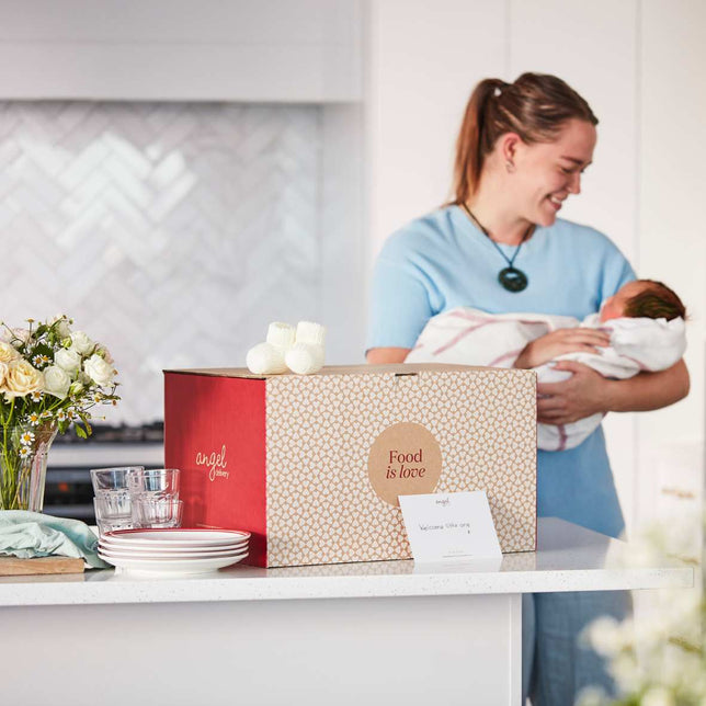Angel Delivery new parent care package with a mum and baby in the background.