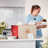 Angel Delivery new parent care package with a mum and baby in the background.