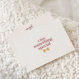 Angel Delivery gift card with the message “A little something special” placed on a textured blanket.